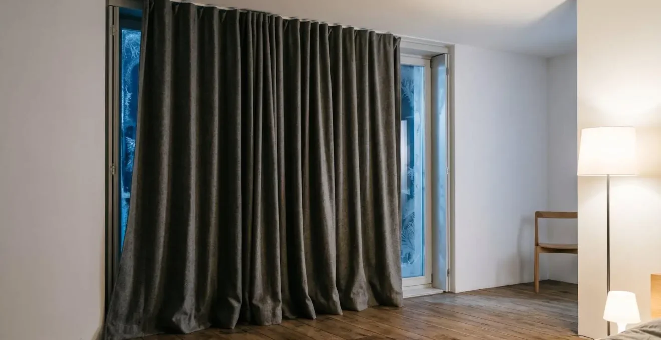 Rideau thermique épais installé devant une fenêtre givrée la nuit